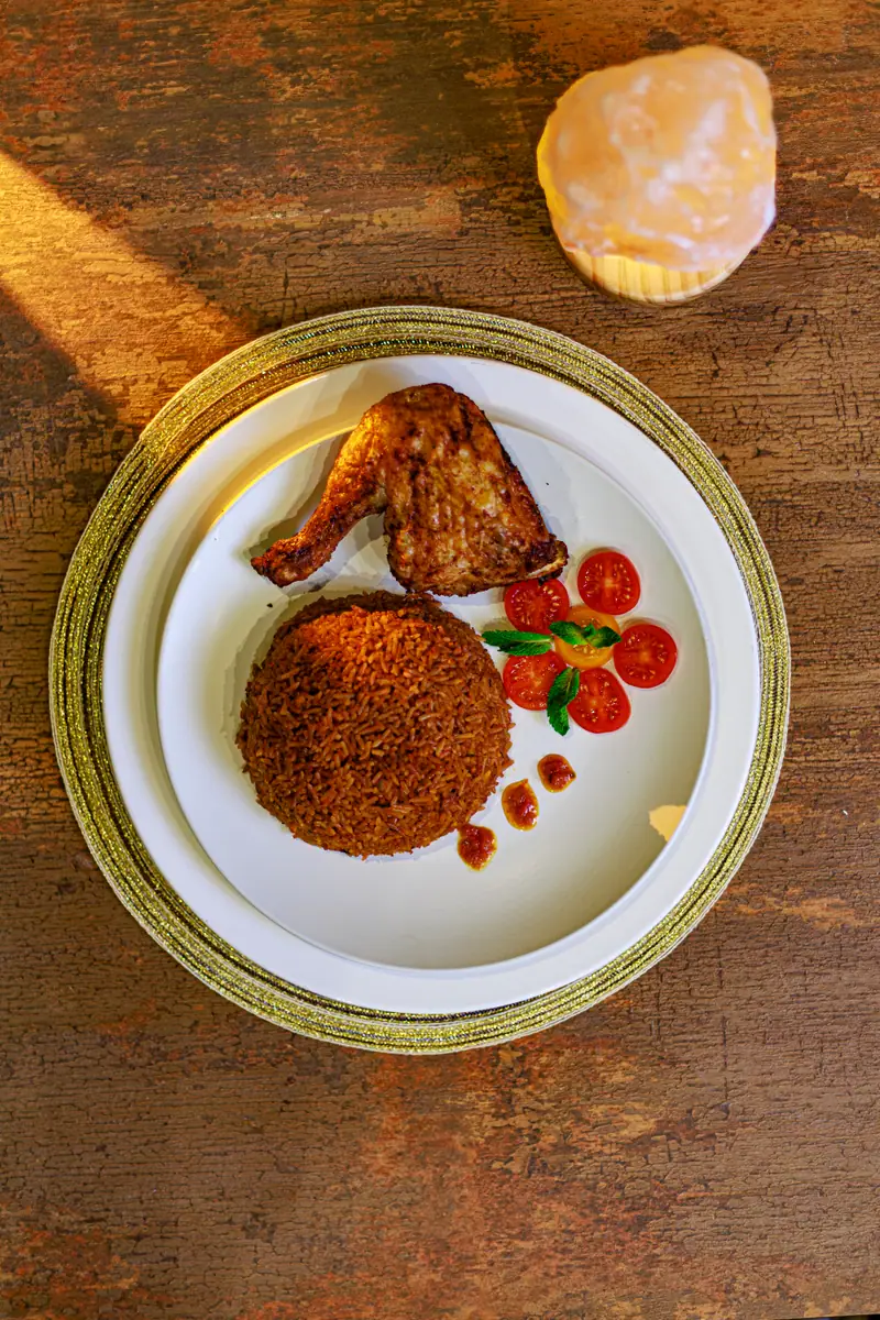 Backyard jollof rice served with quarter chicken
